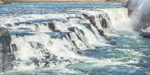 A three-step staircase of the Gullfoss waterfall on Hvita river  as pictured in detail  water plunging into the canyon  mossy cliffs  thick spray  panorama of the rapids 