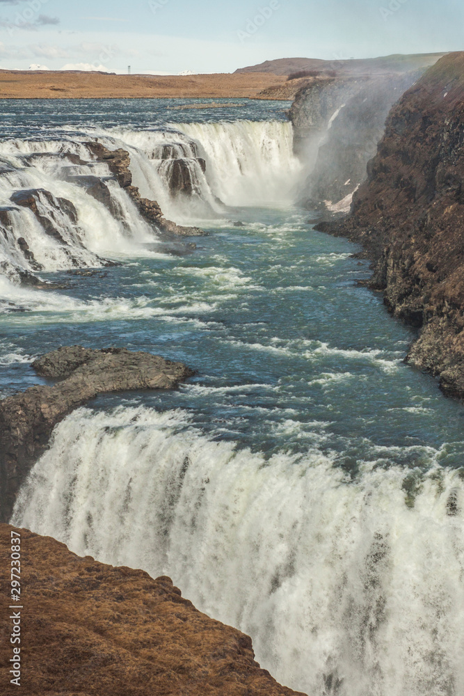 A three-step staircase of the Gullfoss waterfall on Hvita river, as  pictured in detail (water plunging into the canyon, mossy cliffs, thick  spray, panorama of the rapids) Photos | Adobe Stock
