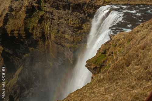 Waterfall Skogafoss  part of Skoga river taking its origin in the Highlands of Iceland  pictured with rainbow due to spray the waterfall produces