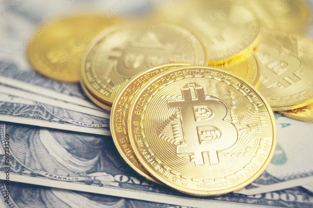 Golden bitcoin cryptocurrency on us dollars close up Golden bitcoin cryptocurrency on us dollars close up