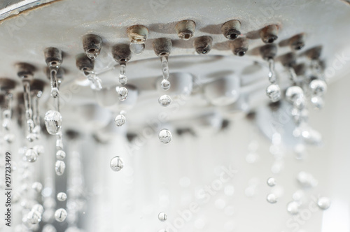Картината върху платно Drops of water drip from the shower faucet.
