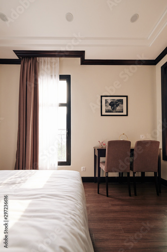 Empty spa resort room with queen bed, small table and two chairs