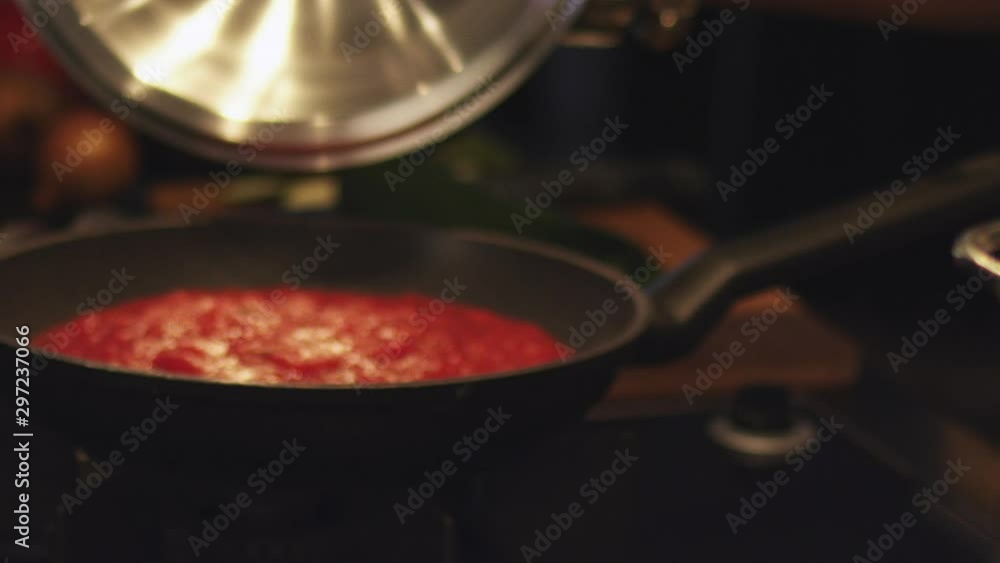 Kitchen chef opening pan, checking red tomato pasta sauce and picking up pepper can. Close up Kitchen chef opening pan, checking red tomato pasta sauce and picking up pepper can. Close up