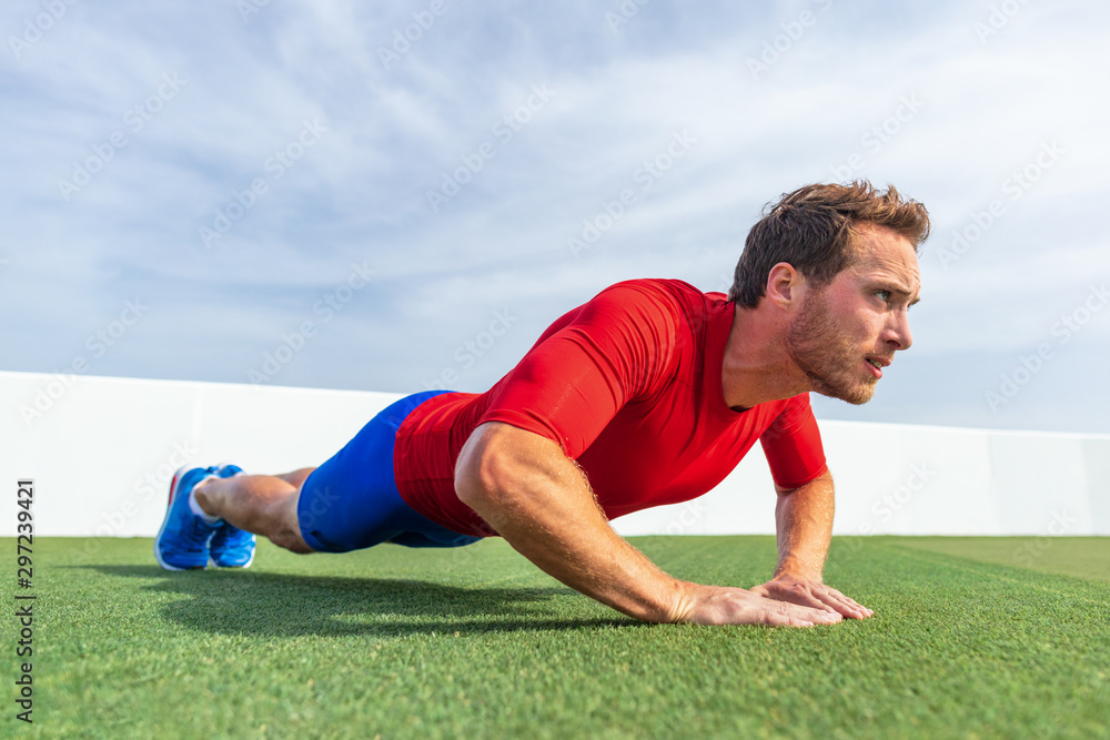 Fitness man doing diamond hand push ups exercises at outdoor grass park. Core body workout athlete planking or doing pushup. Fitness man doing diamond hand push ups exercises at outdoor grass park. Core body workout athlete planking or doing pushup.