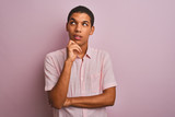 Young handsome arab man wearing casual shirt standing over isolated pink background with hand on chin thinking about question, pensive expression. Smiling with thoughtful face. Doubt concept.