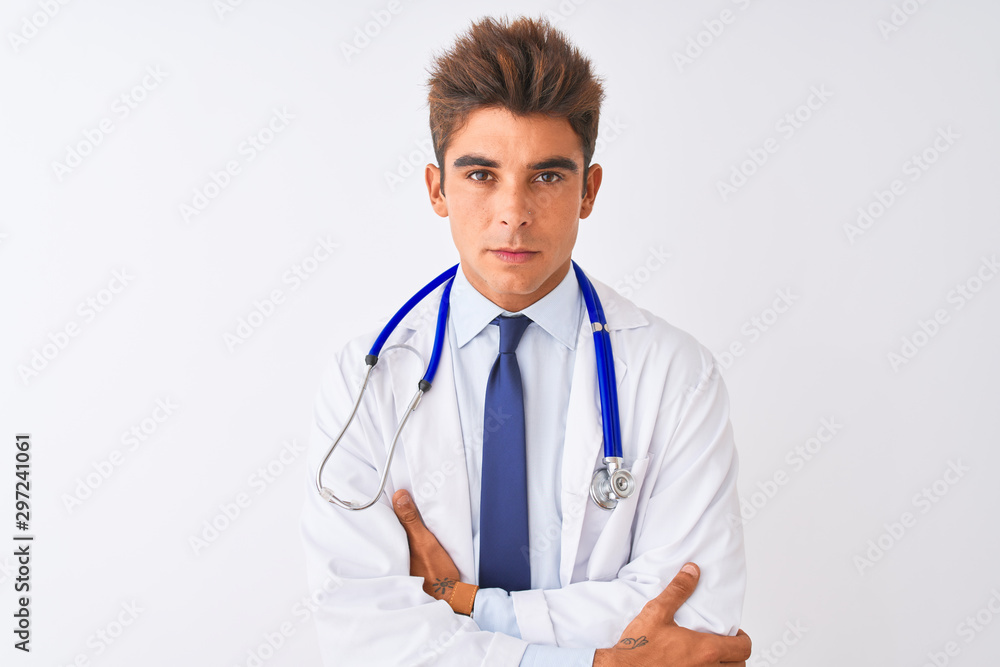 Young handsome doctor man wearing stethoscope over isolated white background skeptic and nervous, disapproving expression on face with crossed arms. Negative person. Young handsome doctor man wearing stethoscope over isolated white background skeptic and nervous, disapproving expression on face with crossed arms. Negative person.