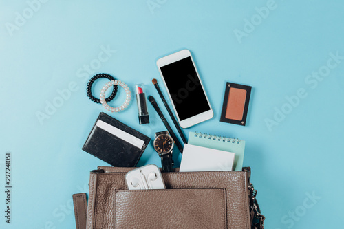 Contents of woman's bag.Top view of Women bag and lady stuff with copyspace on pink background