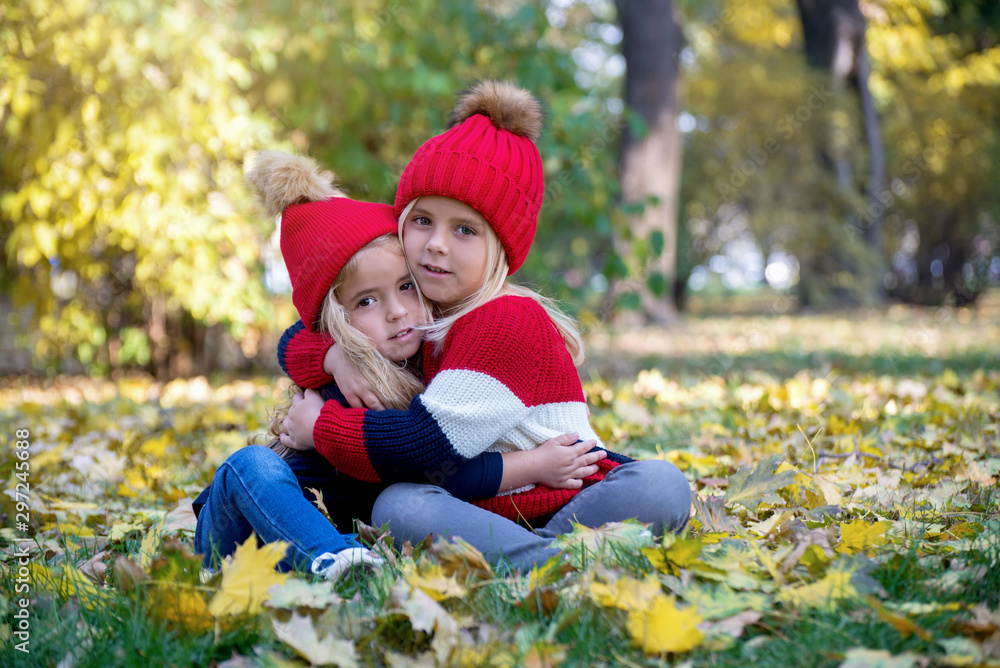 Cute girls at the park playing with Autumn leaves Cute girls at the park playing with Autumn leaves