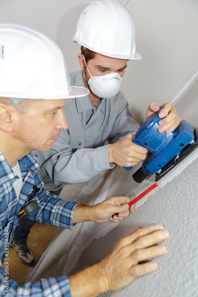 apprentice plasterer sanding the wall apprentice plasterer sanding the wall