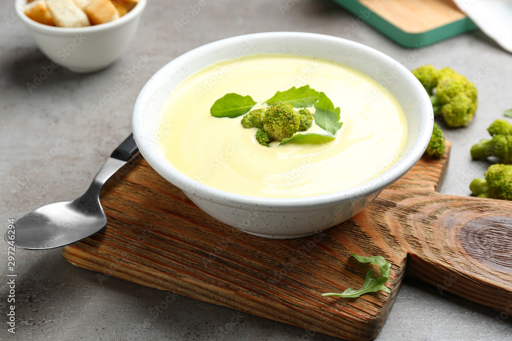 Bowl of cheese cream soup with broccoli served on grey table Bowl of cheese cream soup with broccoli served on grey table