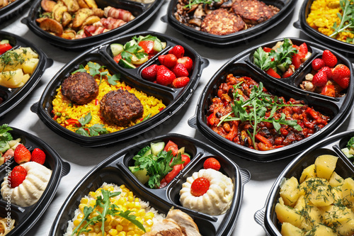 Lunchboxes with different meals on white table. Healthy food delivery