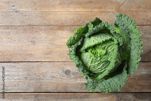 Fresh ripe savoy cabbage on wooden table, top view. Space for text