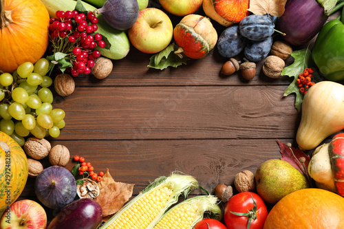 Frame made of autumn vegetables and fruits on wooden background, top view with space for text. Happy Thanksgiving day photo