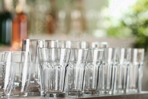 Empty glasses on wooden table against blurred background
