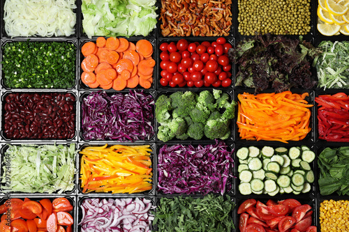 Salad bar with different fresh ingredients as background, top view