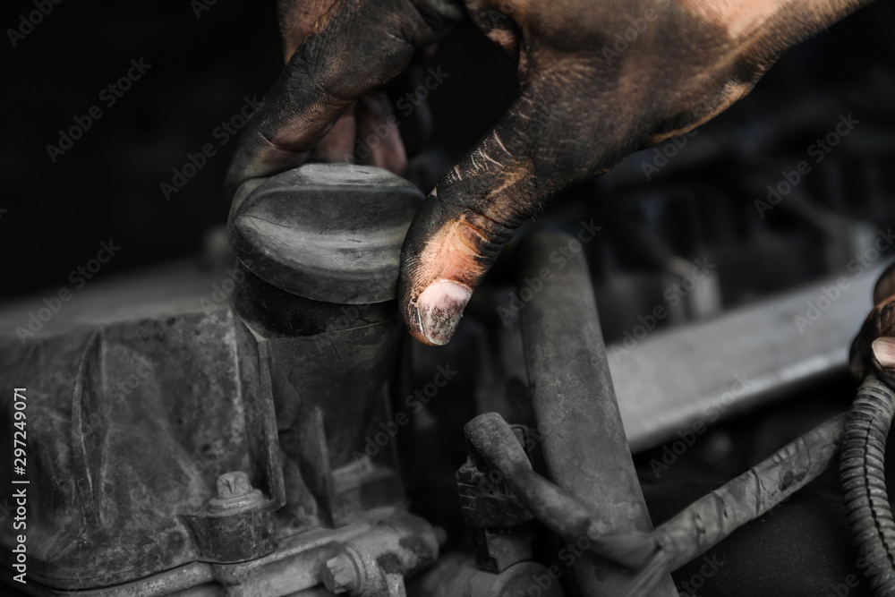 Dirty mechanic fixing car, closeup of hand