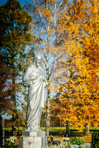 Concrete statue of Jesus Christ painted with silver paint in cemetery
