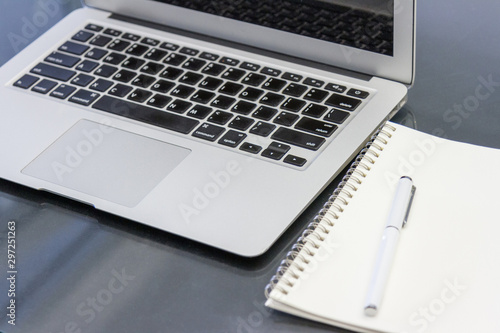 laptop computer and notebook on table