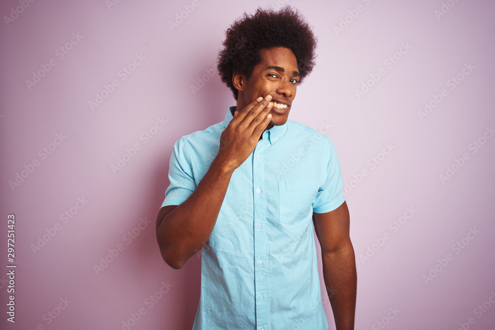 Young american man with afro hair wearing blue shirt standing over isolated pink background touching mouth with hand with painful expression because of toothache or dental illness on teeth Young american man with afro hair wearing blue shirt standing over isolated pink background touching mouth with hand with painful expression because of toothache or dental illness on teeth