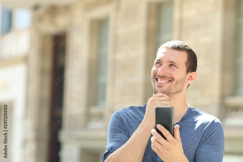 Pensive man holding phone looks at side in the street Pensive man holding phone looks at side in the street