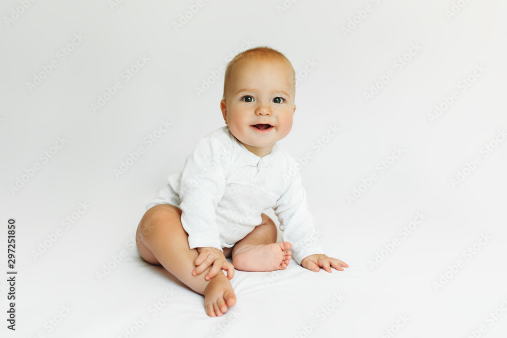 Beautiful happy baby smiling in white on the bed. Beautiful happy baby smiling in white on the bed.