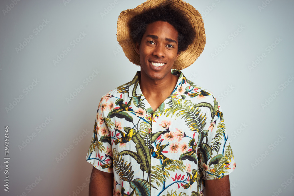 Afro american man on vacation wearing summer shirt and hat over isolated white background with a happy and cool smile on face. Lucky person.