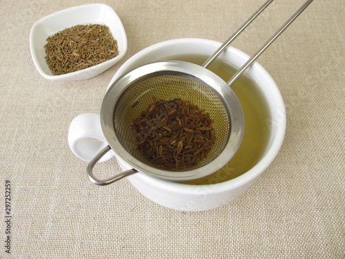 Foto Tea from caraway seeds and caraway fruits in the tea strainer