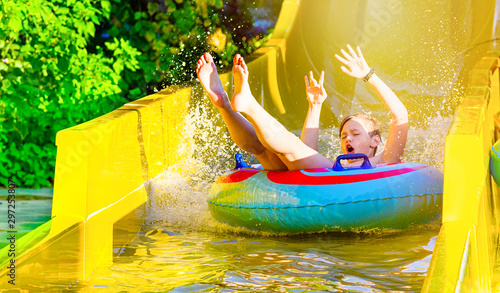 Boy having fun on yellow water slide at water park © Soho A studio