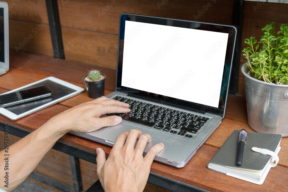man using laptop computer with blank screen on wooden table man using laptop computer with blank screen on wooden table