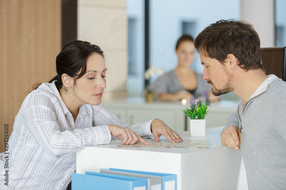 secretary welcoming client at office reception desk