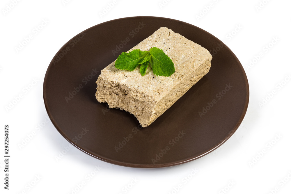 Piece of sunflower halva with mint leaves on brown dish