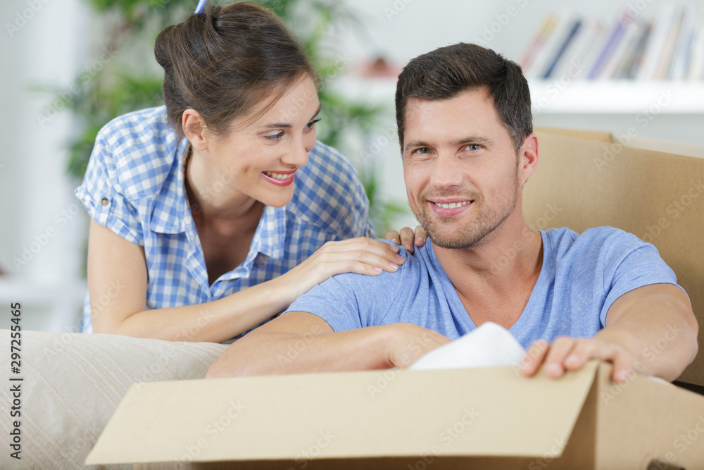 happy couple moving in new home unpacking boxes happy couple moving in new home unpacking boxes