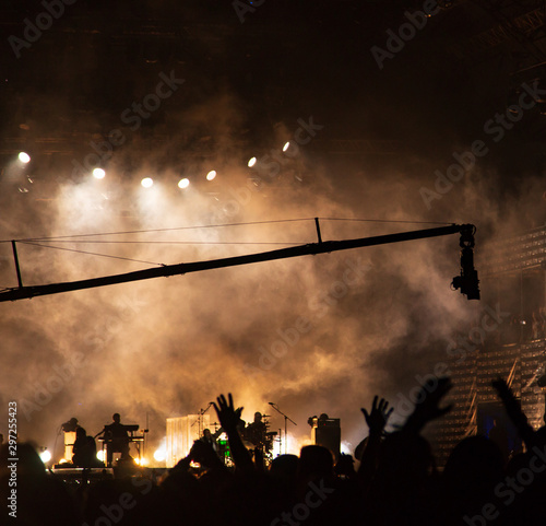 silhouettes of hands by spotlights at a concert