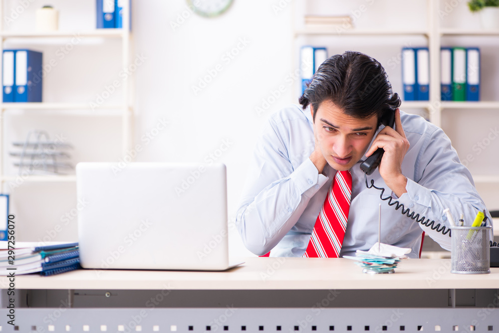 Young male employee suffering in the office Young male employee suffering in the office