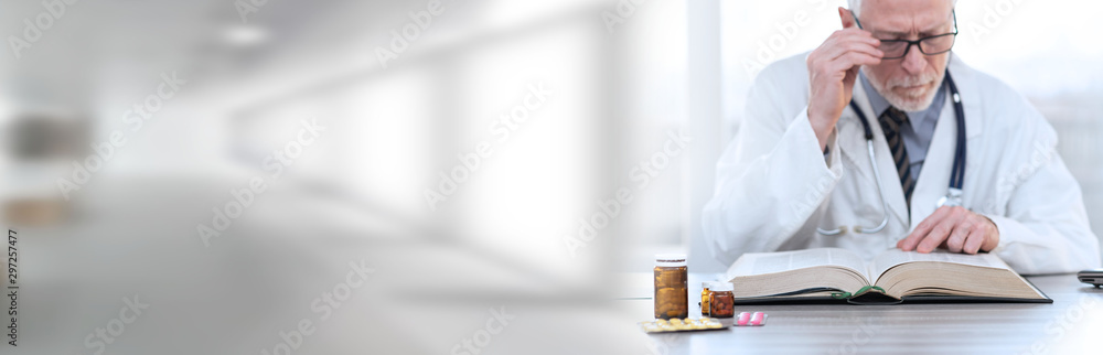Doctor reading a textbook; panoramic banner Doctor reading a textbook; panoramic banner