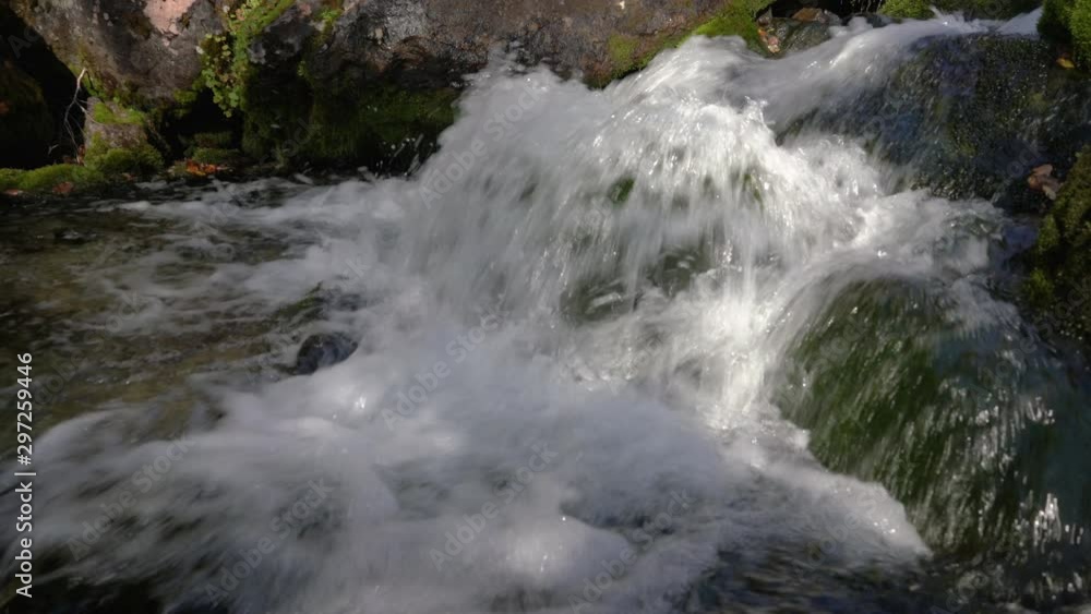 Rugged mountain creek with crystal clean and clear splashing water flowing from glaciers in mountains. Close-up view of environment landscape. Concept: global shortage of clean drinking water. Rugged mountain creek with crystal clean and clear splashing water flowing from glaciers in mountains. Close-up view of environment landscape. Concept: global shortage of clean drinking water.