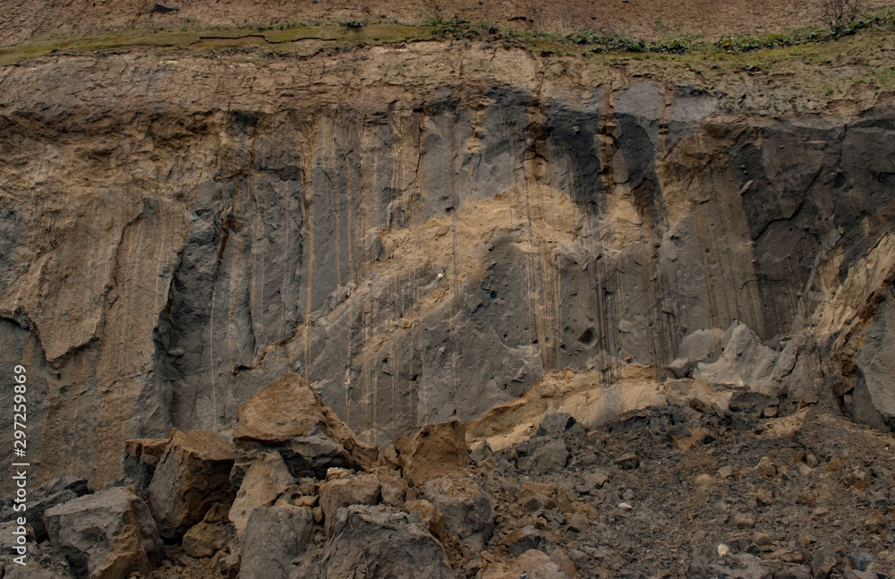 Fototapeta premium Nature background. Steep coastal cliffs. Cracked sand layer, rises filed with clay. rock texture