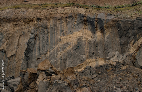 Nature background. Steep coastal cliffs. Cracked sand layer, rises filed with clay. rock texture
