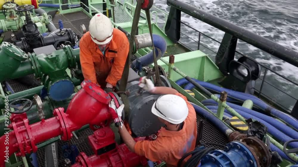 oil tanker Onyx motorman-pump and sailor connect fuel pump meter to pipeline using wrench during heavy pitching oil tanker Onyx motorman-pump and sailor connect fuel pump meter to pipeline using wrench during heavy pitching
