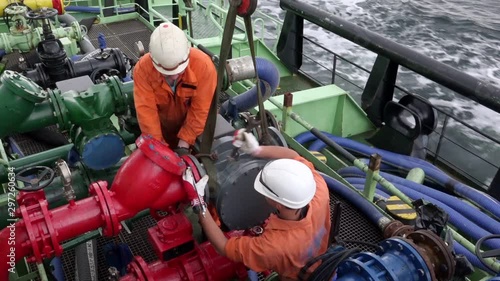 oil tanker Onyx motorman-pump and sailor connect fuel pump meter to pipeline using wrench during heavy pitching