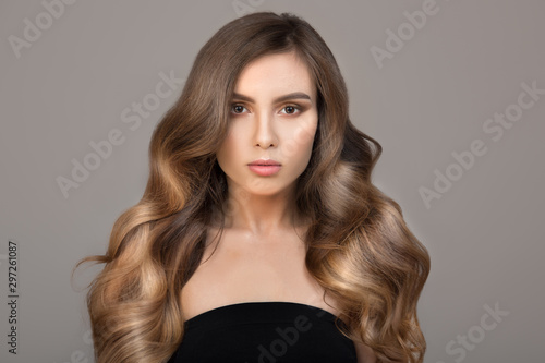 Portrait of a beautiful young brunette woman with long wavy hair. Shiny Thick Hair