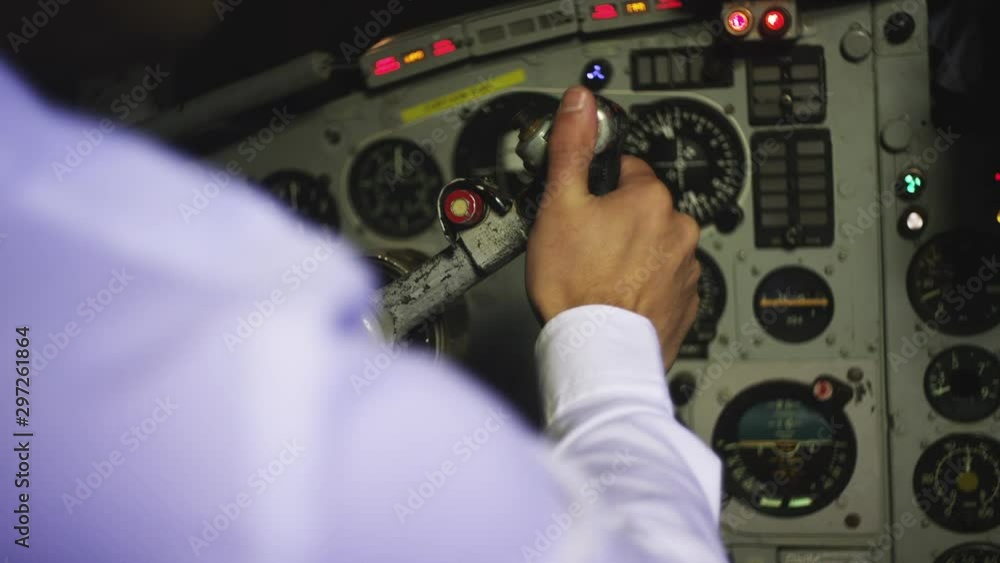 Captain airline pilot in vintage plane pulling control steering wheel