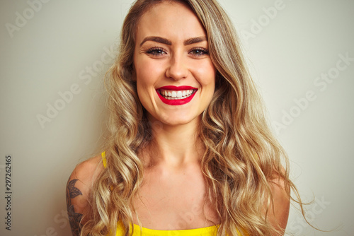 Young beautiful woman wearing yellow t-shirt standing over white isolated background with a happy face standing and smiling with a confident smile showing teeth