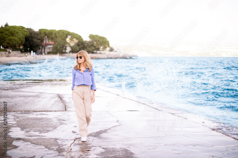 Full length shot of attractive confident woman walking on the beach