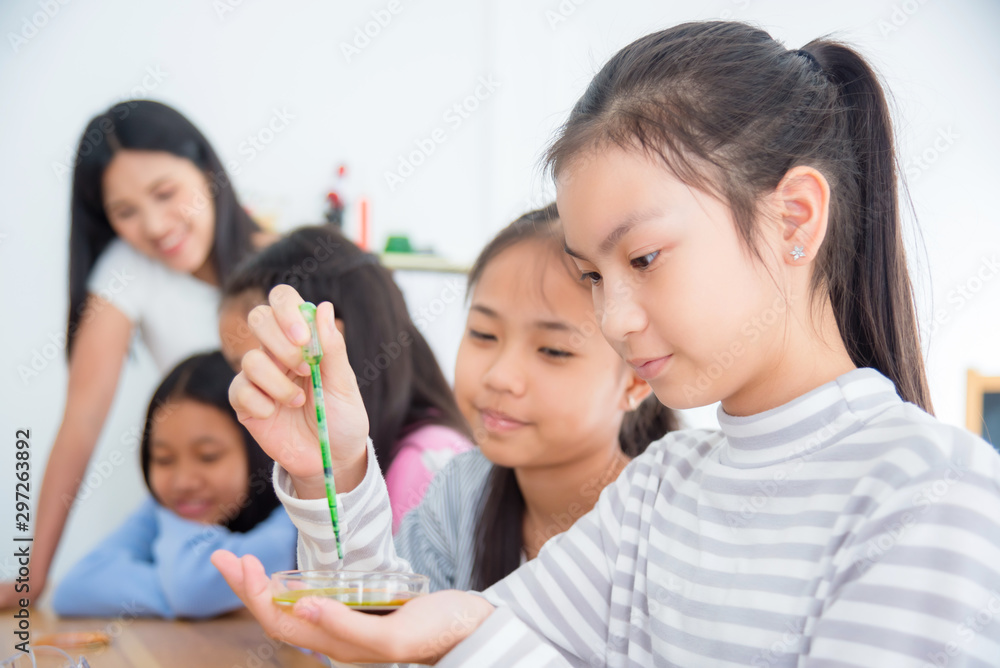 Young asian schoolgirl study science experiment with friend and teacher at school Young asian schoolgirl study science experiment with friend and teacher at school