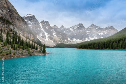 Beautiful turquoise water of Moraine lake in foggy moning, Rocky Mountains, Canada.