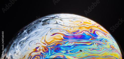 close up of a soap bubble looking like a planet in space.