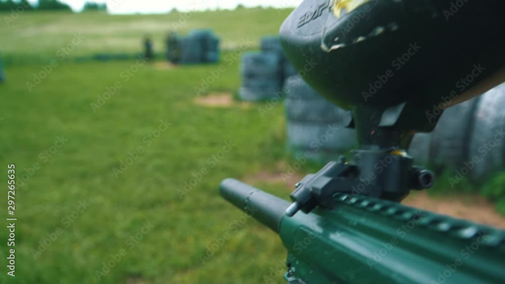 Gun shoots paint balls while playing paintball Gun shoots paint balls while playing paintball