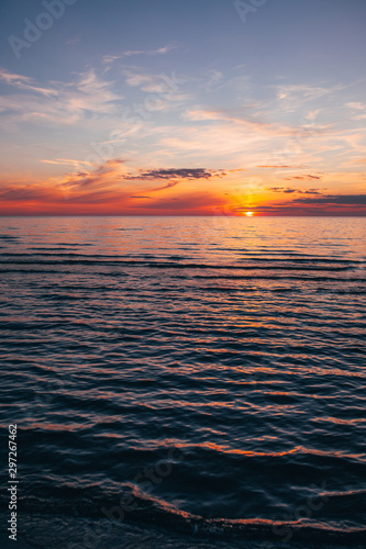 Evening by the sea, beautiful sunset over Baltic seashore, close up view on small waves