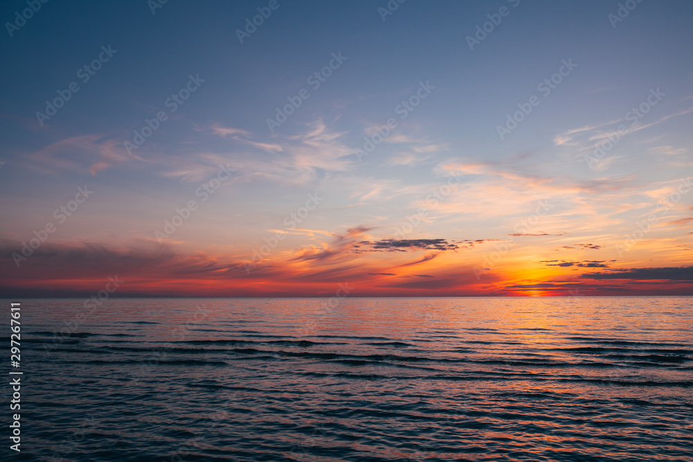 Evening by the sea, beautiful sunset over Baltic seashore, close up view on small waves
